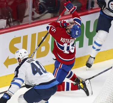 Jesperi Kotkaniemi grabs his face after taking a high stick from Winnipeg Jets' Andrew Copp, not shown, as the Jets' Jordie Benn chases puck during first-period action in Montreal on Monday, June 7, 2021.