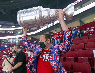 Montreal Canadiens fan Andy Mein brought a copy of the Stanley Cup to the team's  playoff game against the Winnipeg Jets in Montreal on Monday, June 7, 2021.