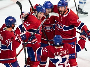 Canadiens centre Nick Suzuki (14) celebrates with his teammates after scoring a power-play goal Sunday night at the Bell Centre.