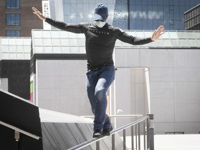 Martin Braunwell  practices his tight rope technique, while walking along a hand rail at Place des Arts on Thursday June 10, 2021 during the COVID-19 pandemic.