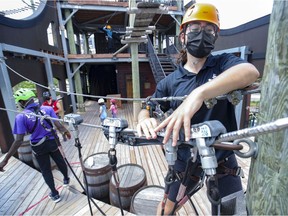 First year CEGEP student Esmée Roy arranges pullies for the zip line course at Voiles en Voiles where she has a summer job, in Montreal's Old Port.
