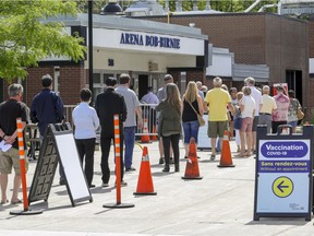 People line up to get into the COVID-19 vaccination clinic in the Bob-Birnie Arena in Pointe Claire, west of Montreal Saturday June 12, 2021.