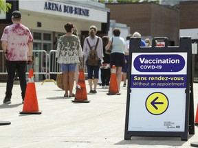 People line up to enter the COVID-19 vaccination clinic in the Bob-Birnie Arena in Pointe Claire on Saturday, June 12, 2021.