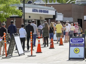 People line up to get into the COVID-19 vaccination clinic at the Bob-Birnie Arena in Pointe-Claire.