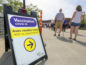 People line up to get into the COVID-19 vaccination clinic at the Bob-Birnie Arena in Pointe-Claire on June 12, 2021.