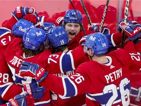 Canadiens players mob Josh Anderson, middle, after he scored the winning goal in overtime Friday night at the Bell Centre.