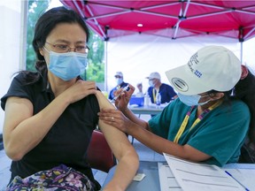 Lu Chen gets vaccinated by nurse Sabiha Shareef during a walk-in vaccination clinic outside the Bell Centre in Montreal on June 18, 2021.