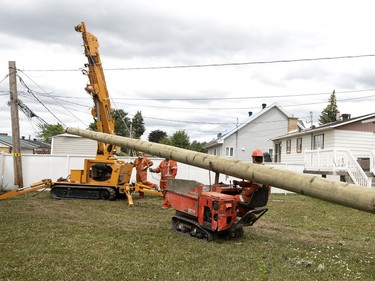 A work crew contracted by Hydro Québec prepares to install new poles after a tornado struck and downed several hydro poles in Mascouche north of Montreal on Tuesday, June 22, 2021.