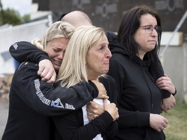 The widow of Jacques Lefebvre is comforted by her family as they watch Quebec premier François Legault arrives to visit, after a tornado struck in Mascouche north of Montreal on Tuesday, June 22, 2021.