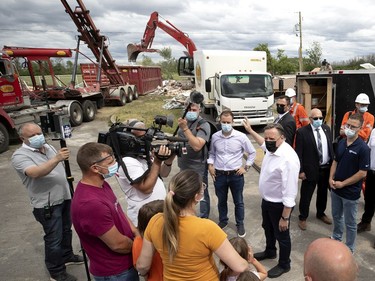 Quebec premier François Legault, right, visits with the Hamel and Barbe family as their home is demolished after a tornado struck in Mascouche north of Montreal on Tuesday, June 22, 2021.