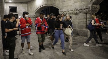 People walk away after police launched tear gas canisters in front of the Bell Centre after the Montreal Canadiens defeated the Vegas Golden Knights June 24, 2021.