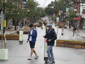 People make their way along the pedestrian section of Mont Royal Avenue during a rainy Saturday June 26, 2021.