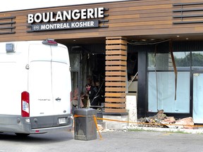 Montreal police arson investigators look through damage caused by a fire bomb at Boulangerie Montreal Kosher in the Saint-Laurent borough of Montreal June 28, 2021.