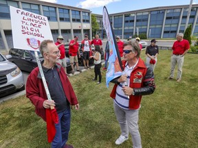 Former Lindsay Place High School teacher Ian Howarth, left, and Peter Bolle, president of the Lindsay Place Alumni Foundation with other former teachers and students outside the school in Pointe-Claire, Wednesday, June 23. Wednesday was the last day of school and last day for the name which will change to St. Thomas High with the relocation of the other English school in Pointe-Claire starting in September.