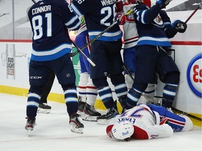 Jake Evans #71 of the Montreal Canadiens lies on the ice injured from a hard check by Mark Scheifele #55 of the Winnipeg Jets after Evans's third-period empty-net goal in Game 1 of the Second Round of the 2021 Stanley Cup Playoffs on June 2, 2021 at Bell MTS Place in Winnipeg.