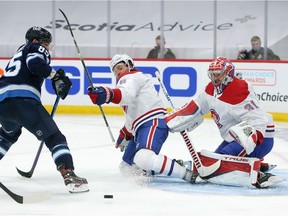 Montreal Canadiens Ben Chiarot and Carey Price block a shot from Jets Mathieu Perreault during Game 2 of the second round of the Stanley Cup Playoffs on June 4, 2021, at Bell MTS Place in Winnipeg.