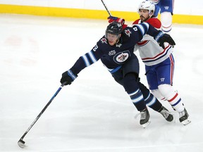 Jets' Andrew Copp moves the puck under pressure from Canadiens' Phillip Danault in Game 2 of the second round of the 2021 Stanley Cup playoffs on Friday, June 4, 2021, at Bell MTS Place in Winnipeg. Danault said season-long adversity allowed the Canadiens to turn things around after falling behind 3-1 in the opening series against Toronto.