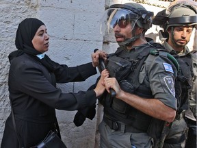 A Palestinian woman confronts Israeli security forces outside the Damascus gate in east Jerusalem, on June 15, 2021, ahead of the March of the Flags, which celebrates the anniversary of Israel's 1967 occupation of the city's eastern sector.