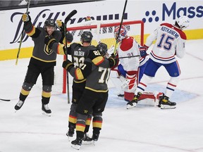 Nick Holden #22 of the Vegas Golden Knights celebrates with Jonathan Marchessault #81 and William Karlsson #71 after scoring a goal in the third period against the Montreal Canadiens during Game One of the Stanley Cup Semifinals at T-Mobile Arena on June 14, 2021 in Las Vegas, Nevada.