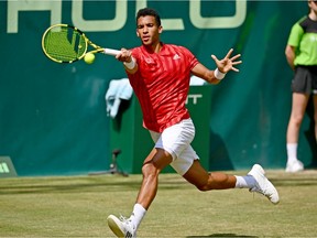 Félix Auger-Aliassime plays a forehand in his match against Roger Federer of Switzerland at Noventi Open on June 16, 2021, in Halle, Germany.