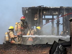 Montreal firemen work to put out a blaze on Mont-Royal Ave. in Montreal on Wednesday, June 9, 2021.