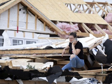 Laurence Barbe asses the damage as her home sits in the backyard after being ripped from its moorings after a tornado struck in Mascouche north of Montreal on Monday, June 21, 2021. Barbe said her family was spared by only a matter of minutes as her children would have been home and in the house.