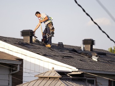 Roofing crews repair damaged shingles after a tornado struck in Mascouche north of Montreal on Monday, June 21, 2021.