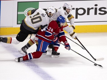 Vegas Golden Knights center Nicolas Roy (10) and right wing Alex Tuch (89) lean on Phillip Danault (24) during NHL semi final game 6  in Montreal on Thursday, June 24, 2021. Danault succeeded in moving the puck up the ice.