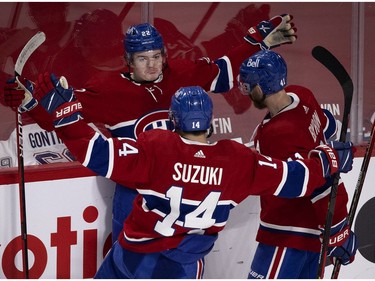 Canadiens' Cole Caufield, facing, Nick Suzuki and Paul Byron celebrate Caufield's goal in the second period Thursday night at the Bell Centre.