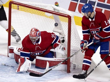 Carey Price (31) tips the puck up past Nick Suzuki (14) during NHL semi final game 6 against the Vegas Golden Knights in Montreal on Thursday, June 24, 2021.