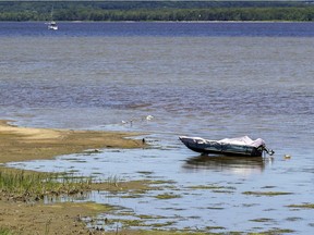 A boat sits on the lake bottom in Vaudreuil-Dorion. "While we are concerned, we can’t make it rain," the Lake Ontario-St. Lawrence River Board says.