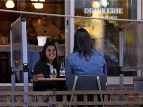 Anais Berzi sits with a friend and enjoys an evening at the Drinkerie as COVID-19 restrictions eased in Montreal.