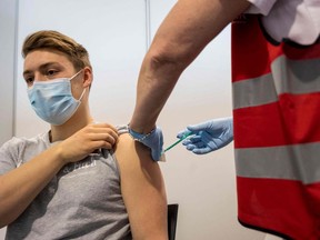 A young employee receives the Pfizer vaccine in Hanau, western Germany.
