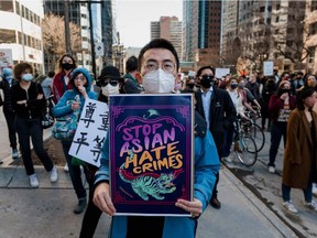 People march in downtown Montreal during a demonstration against anti-Asian racism on March 21, 2021.