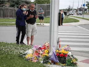 Abdullah Alzureiqi and his daughter Hala say a prayer at the fatal crime scene where a man driving a pickup truck jumped the curb and ran over a Muslim family in what police say was a deliberately targeted anti-Islamic hate crime, in London, Ontario, Canada June 7, 2021.