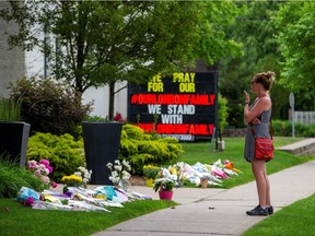 A woman stops in front of the London Muslim Mosque, about 500 metres from where police arrested a suspect in the killing of four members of a Muslim family in London, Ont.