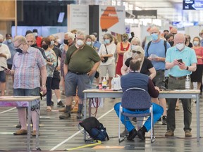 Some people eligible for a second COVID-19 vaccination shot wait in line at the Palais des congrès vaccination site in Montreal, Sunday, June 6, 2021.