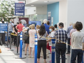 People line up to get their COVID-19 vaccine on Thursday. Authorities are urging the public to remain patient during the ramp-up in vaccinations.