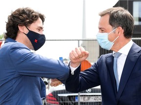 Belgian Prime Minister Alexander De Croo and Canadian Prime Minister Justin Trudeau bump arms during their visit to pharmaceutical company Pfizer in Puurs, Belgium June 15, 2021.