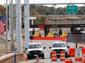 U.S. Customs vehicles stand near a sign reading the border is closed to non-essential traffic at the Canada-United States border crossing at the Thousand Islands Bridge to combat the spread of the coronavirus disease (COVID-19) in Lansdowne, Ont., on Sept. 28, 2020.