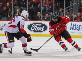 New Jersey Devils defenceman P.K. Subban skates with the puck against Ottawa Senators centre Colin White during a home game in November 2019.