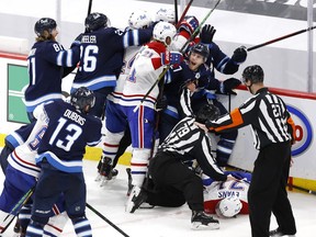 Winnipeg Jets' Nikolaj Ehlers (27) attempts to keep players away from injured Canadiens' Jake Evans (71) after a hit by Jets' Mark Scheifele (not pictured) in Game 1 of the second round of the 2021 Stanley Cup Playoffs at Bell MTS Place in Winnipeg.