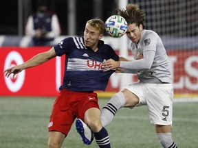 Montreal Impact defender Luis Binks, right, battles New England Revolution forward Adam Buksa for the ball during the first half of MLS match at Gillette Stadium in Foxborough, Mass., on Nov. 20, 2020.