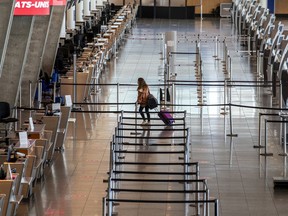 A lone passenger heads to the departure gate at Montréal-Pierre Elliott International Airport in Montreal Thursday May 7, 2020.