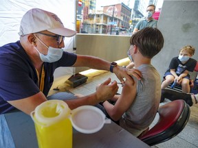 Yann Fraioli, 13, gets vaccinated by nurse El Mahfoud Mourouane during a walk-in vaccination clinic outside the Bell Centre prior to a Canadiens playoff game last month.