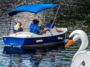 A man and members of his family tour along at four kilometres per hour in a battery powered boat from H2O Adventures on the Lachine Canal.