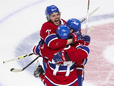 Montreal Canadiens Jake Evans, left, celebrates goal by teammate Alexander Romanov, right, with Brett Kulak during the third period of Game 4 of the Stanley Cup final against the Tampa Bay Lightning in Montreal on Monday, July 5, 2021.