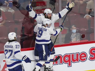 Tampa Bay Lightning winger Pat Maroon (14) celebrates his game-tying goal with teammate Tyler Johnson while Ryan McDonagh joins in during the third period of Game 4 of the Stanley Cup final against the Montreal Canadiens in Montreal on Monday, July 5, 2021.