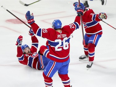 Montreal Canadiens' Josh Anderson lies on his back as he celebrates his winning goal in overtime with teammates Jeff Petry and Cole Caufield during Game 4 of the Stanley Cup final on Monday night at the Bell Centre.