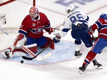 Tampa Bay Lightning right wing Nikita Kucherov (86) takes a shot on Montreal Canadiens goaltender Carey Price (31) as Canadiens right wing Brendan Gallagher (11) lines up to hit Kucherov during Game 4 of the Stanley Cup final in Montreal on Monday, July 5, 2021.